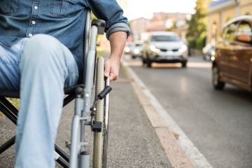 Man in wheelchair next to road.
