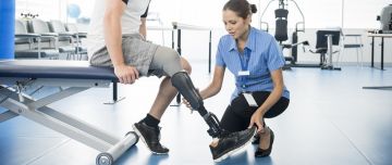 Physiotherapist assisting a person with their prosthetic leg.