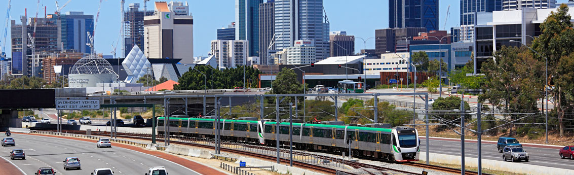 Perth City Skyline with train running down the middle of the freeway.